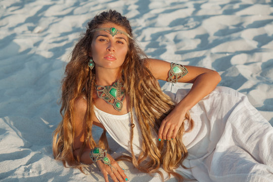 attractive bohemian style woman lying on the sand