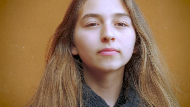 A young teenage girl smiles and laughs modestly in slow mo