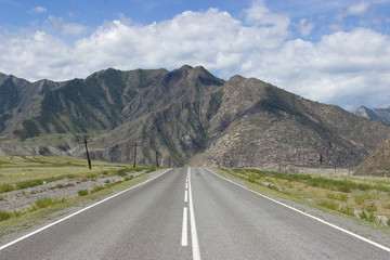 Дорога в горы.\Асфальтная дорога ведёт в горы на фоне красивого летнего неба.