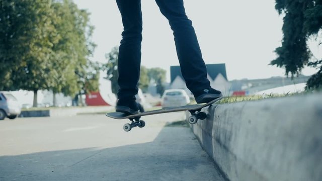 Skateboarder doing a skateboard tail board slide over the rail at the skate park.