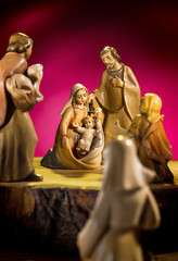 Krippenfiguren auf Holz mit rotem Hintergrund