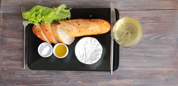 Simple diet: bread and cheese served with white wine, olive oil, green salad, salt. Wide image