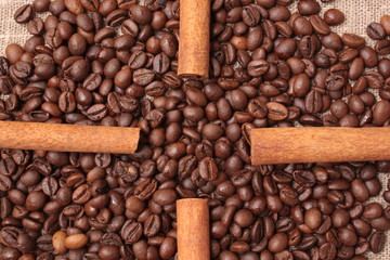 Coffee beans and cinnamon on a sacking background