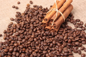 Coffee beans and cinnamon on a sacking background