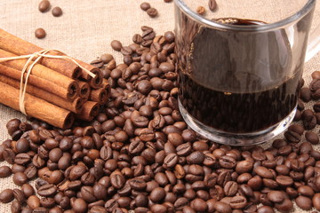 Coffee beans and cinnamon on a sacking background