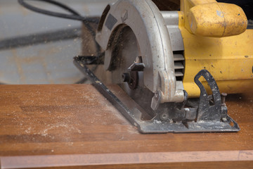 carpenter use electric saw to sawing wood