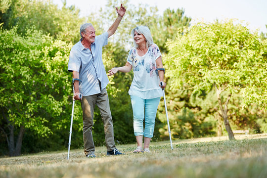Fröhliche Senioren mit Krücken im Park