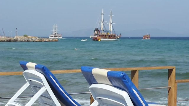 View of Turkish Gulet cruise boats taking tourists out on the Aegean Sea for the day, focus is on the sun loungers