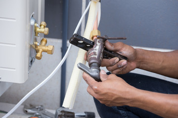 installation of air conditioner, worker connects copper pipe