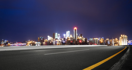 cityscape and skyline of chongqing at night from empty road