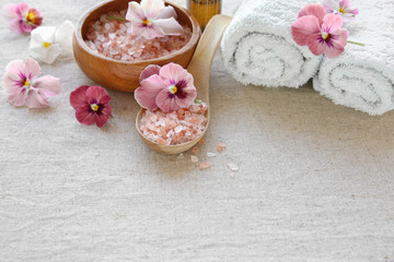 Fototapeta na wymiar Pink sea salt and flowers, Spa setting, copy space background, s