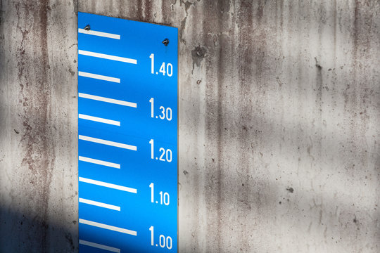 Blue tide level measurement scale on concrete wall