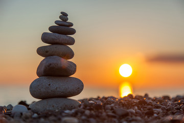 The rock cairn on the beach, on a beautiful bright sunset