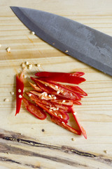 Sliced red pepper on a wooden cutting board and knife.In selecti
