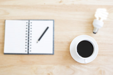 Black coffee in selective focus on blurry wood table with blurry