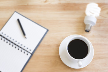 Black coffee in selective focus on blurry wood table with blurry