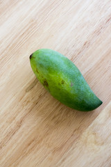 Whole Green Mango on a wooden table.In selective focus.