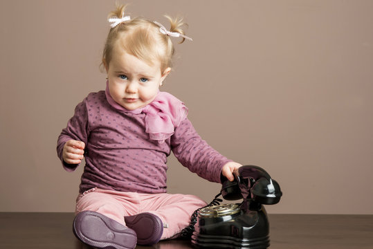 Funny angry little girl taking a phone