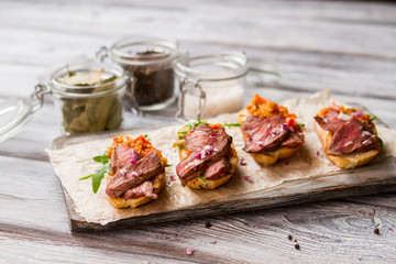 Toasts with slices of meat. Herb and mixture of vegetables. Bruschetta with chopped onion. Tasty dish cooked at home.