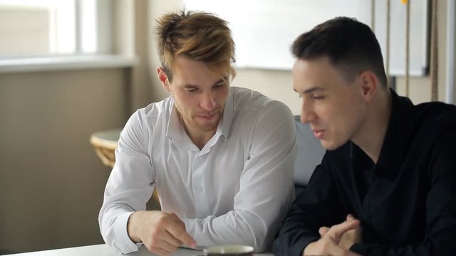 Two men talk with each other during coffee break.