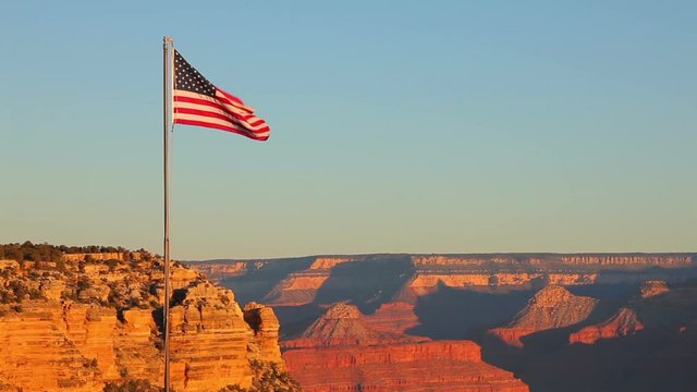 A beautiful morning shot of the Grand Canyon with the US flag blowing in the breeze.