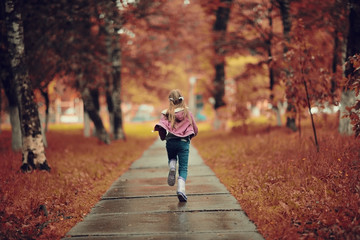 Girl 6-7 runs in the autumn park