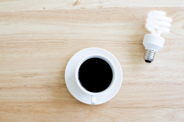 Black coffee on wood table.And brighten lamp.