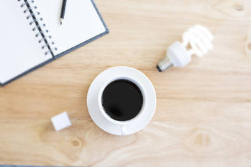 Black coffee in selective focus on blurry wood table with blurry