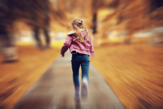Girl 6-7 runs in the autumn park