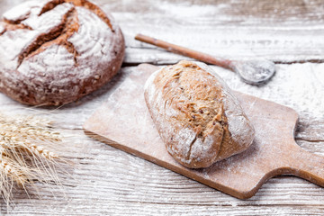 Delicious fresh bread on wooden background