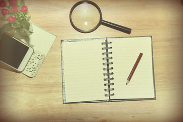 Open Blank notebook and pencil with magnifying glasses and