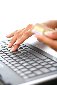 plan serré de mains de femme sur un ordinateur avec une carte bancaire