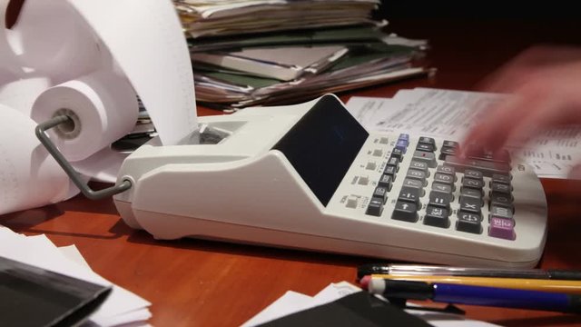 Close up of a man's hand, hard at work using a calculator.
