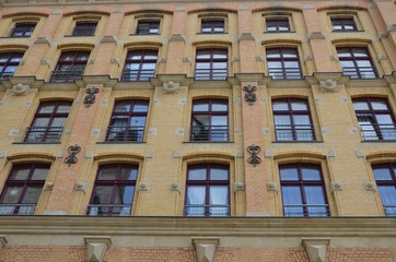 Fototapeta premium Facade of red brick building with many windows