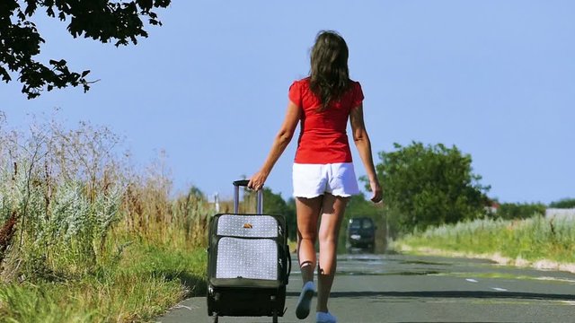 
Slow motion. Sexy woman  slender legs and body with  suitcase on  road.

