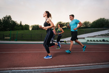 People running at the stadium. Group fitness training