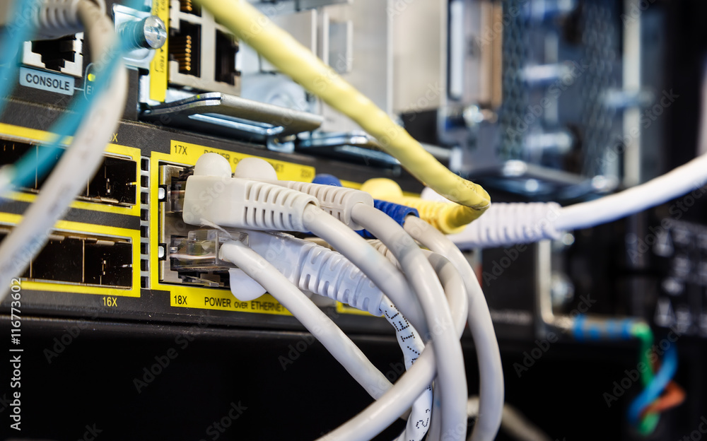 Poster rack in the data center with working equipment with optical and utp cables