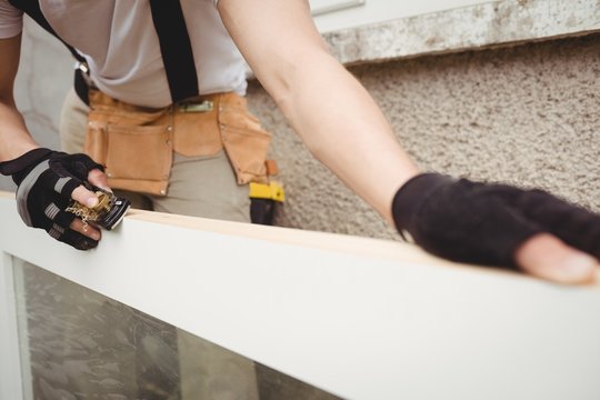 Carpenter leveling a wooden frame with block plane