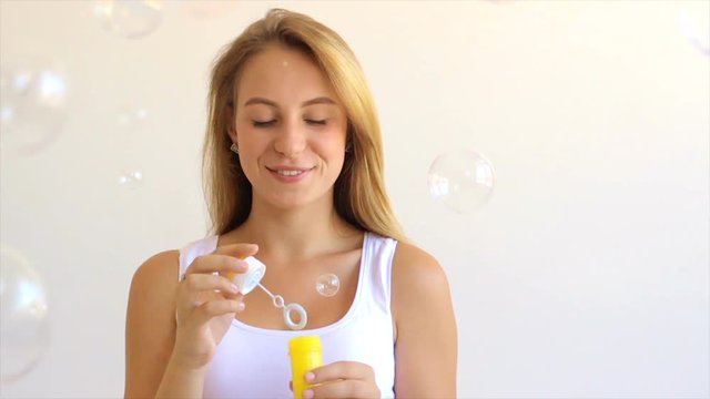 Cute girl blowing soap bubbles