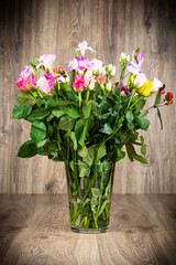Mix of flowers in the vase on wooden background