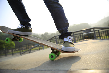 Fototapeta na wymiar young woman skateboarder skateboarding at skatepark