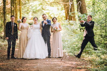 bride and groom with happy groomsmen and bridesmaids having fun and popping champagne, hilarious moment. Funny guys