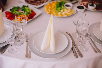 Beautifully decorated table in the restaurant. Linen tablecloth and napkin