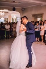 bride and groom have first dance. Groom kisses a bride bending her over during their first dance