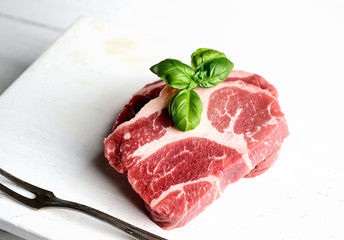 Raw marbled beef on a cutting board and fork