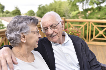 Portrait of elderly couple relaxing outside senior home