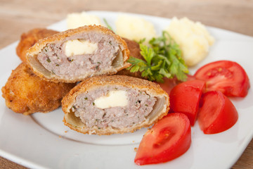 Breaded and fried meat, served with potato and tomato