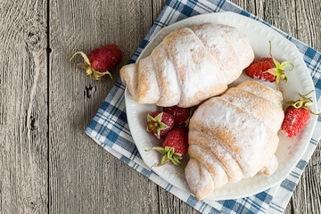  Dessert.  Croissants and fresh raspberries on dessert plate on gray wooden table.