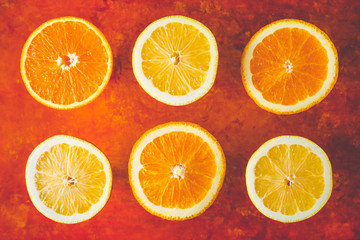 Obraz premium Lemon and orange slices on the terracotta background horizontal