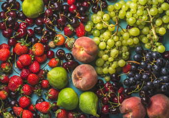 Healthy summer fruit variety. Black and green grapes, strawberries, figs, sweet cherries and peaches, top view, horizontal composition